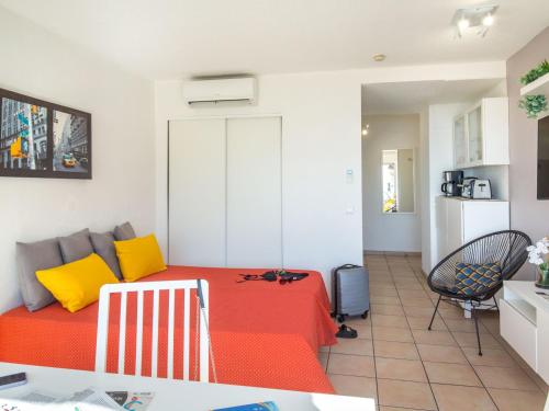 Cette chambre comprend un lit avec des oreillers jaunes et oranges. dans l'établissement Studio climatisé 2 pers proche plage et commerces avec balcon et wifi à Saint-Raphaël - FR-1-466A-28, à Saint-Raphaël