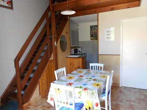une salle à manger avec une table et un escalier dans l'établissement Charmante Maisonnette à 200m de la Plage avec Jardin et Parking Privé - FR-1-476-9, à La Faute-sur-Mer