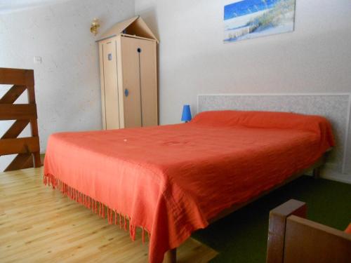 - une chambre avec un lit rouge et une armoire dans l'établissement Charmante Maisonnette à 200m de la Plage avec Jardin et Parking Privé - FR-1-476-9, à La Faute-sur-Mer