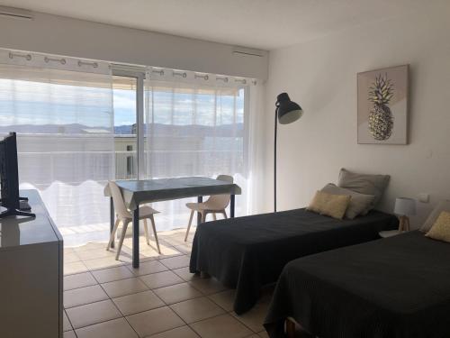 - une chambre avec un lit, une table et un balcon dans l'établissement Studio climatisé pour 2, proche plage et commerces, animaux admis, WiFi, parking - FR-1-466A-20, à Saint-Raphaël