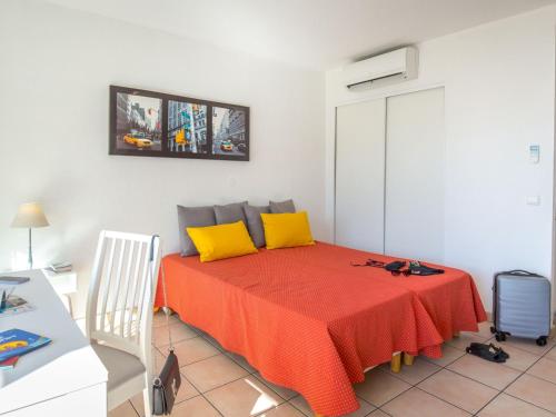 - une chambre avec un lit rouge et des oreillers jaunes dans l'établissement Studio climatisé 2 pers - Vue mer - Proche plage/commerces - Accès WiFi gratuit - Parking dispo - FR-1-466A-34, à Saint-Raphaël