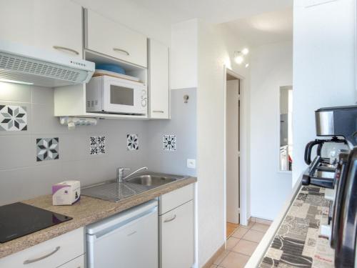 une cuisine avec un évier et un micro-ondes dans l'établissement Studio climatisé 2 pers - Vue mer - Proche plage/commerces - Accès WiFi gratuit - Parking dispo - FR-1-466A-34, à Saint-Raphaël