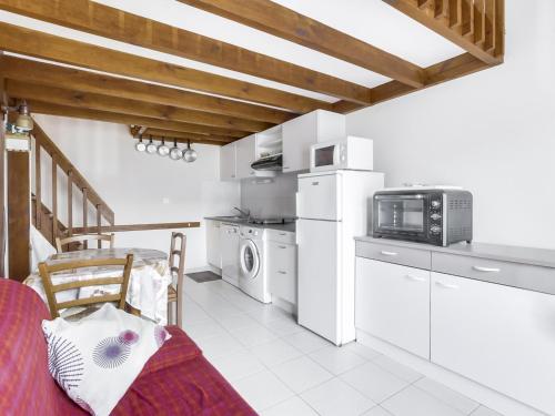 une cuisine avec des appareils électroménagers blancs et une table avec un four micro-ondes dans l'établissement Maison Jumelée à Biscarrosse Plage, Proche Océan et Centre, 6 Pers, Parking Privé, Récent, Non Fumeur - FR-1-521-67, à Biscarrosse-Plage