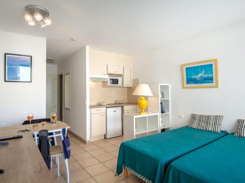 Cette chambre comprend un lit, une table et une cuisine. dans l'établissement Studio 2/3 personnes près plage, climatisé, balcon, parking, WiFi, petit-déjeuner, Saint-Raphaël - FR-1-466A-37, à Saint-Raphaël