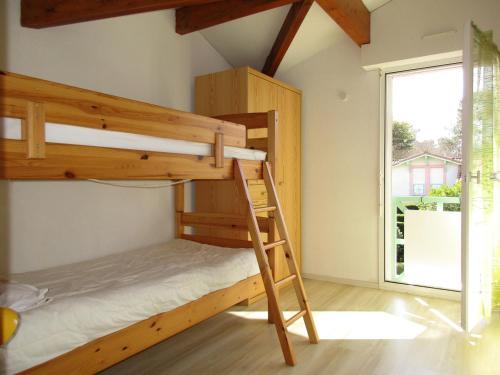 a bunk bed in a room with a ladder at Maison T3 à Biscarrosse Lac - 4/6 pers - Jardin, terrasse, proche lac et pistes cyclables - FR-1-521-116 in Biscarrosse