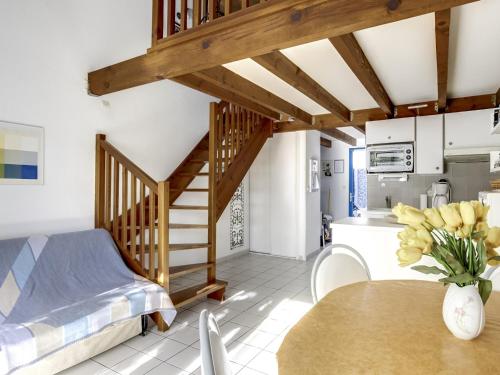 Cette chambre comprend un lit et une table avec un vase de fleurs. dans l'établissement Maison T2 mezzanine près de l'océan - 5/6 personnes - terrasse et parking privé - 40600 Biscarrosse - FR-1-521-23, à Biscarrosse-Plage