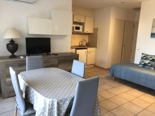une cuisine et un salon avec une table et des chaises dans l'établissement Studio climatisé proche plage, commerces et gare avec balcon, parking et wifi - FR-1-466A-5, à Saint-Raphaël