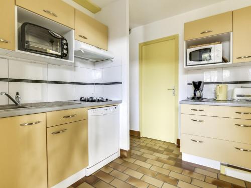 une cuisine avec un évier et un micro-ondes dans l'établissement Maison T3 avec jardin, terrasses, proche plage - calme - 6 pers, Biscarrosse - FR-1-521-68, à Biscarrosse-Plage