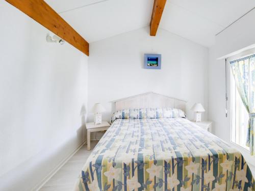 um quarto branco com uma cama e uma janela em Maison Biscarrosse, 2 pièces, 6 personnes - FR-1-521-97 em Biscarrosse