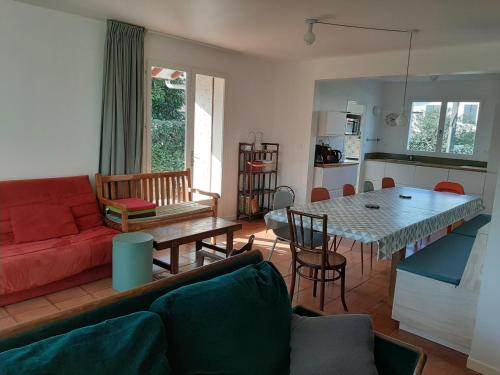 un salon avec un canapé rouge et une table dans l'établissement Maison 3* à Hendaye, proche plage et commerces, jardin privé, parfait pour familles et amis - FR-1-239-492, à Hendaye