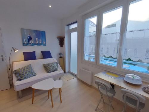 Cette petite chambre comprend un lit et un bureau avec des chaises. dans l'établissement Studio rénové à Port-Louis, proche plage et centre, jardin commun, 2 couchages, WiFi inclus - FR-1-349-143, à Port-Louis