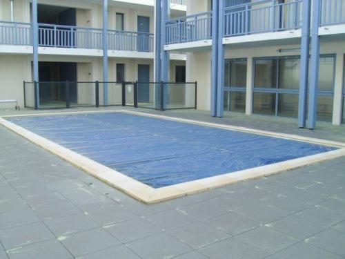 a blue basketball court in front of a building at Appartement T3 avec piscine, sauna en front de mer à Biscarrosse Plage - FR-1-521-1 in Biscarrosse-Plage