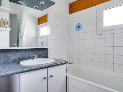 La salle de bains blanche est pourvue d'un lavabo et d'une baignoire. dans l'établissement Maison 4 pers. avec jardin clos, proche plage et centre, quartier calme - FR-1-521-24, à Biscarrosse-Plage