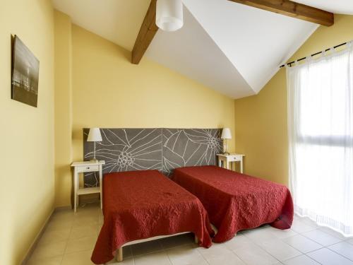 um quarto com 2 camas com lençóis vermelhos e uma janela em Maison Biscarrosse Plage, 3 pièces, 6 personnes - FR-1-521-31 em Biscarrosse-Plage