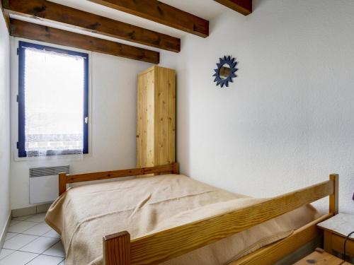 une chambre avec un lit et une horloge au mur dans l'établissement Biscarrosse Plage: Appartement T2 Mezzanine, 250m de la mer - FR-1-521-49, à Biscarrosse-Plage