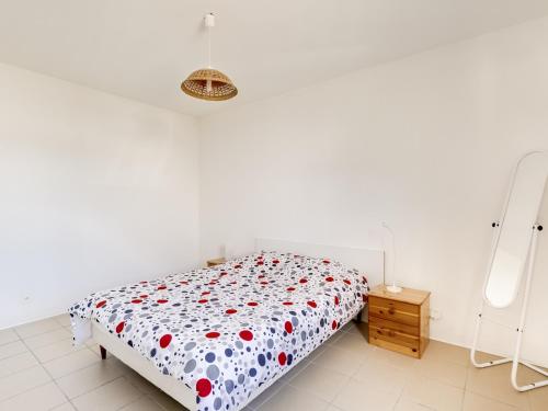una camera bianca con un letto con fiori rossi di Appartement Biscarrosse Plage, 2 pièces, 2 personnes - FR-1-521-62 a Biscarrosse-Plage