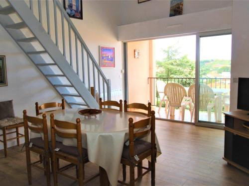 une salle à manger avec une table et des chaises et un escalier dans l'établissement Appartement T3 climatisé avec garage et terrasse à Collioure - FR-1-309-265, à Collioure