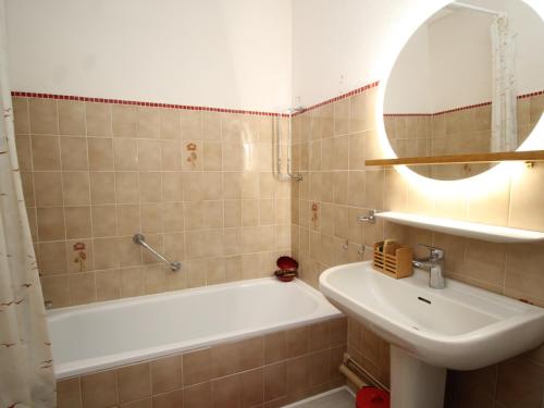 une salle de bain avec un lavabo, une baignoire et un miroir dans l'établissement Appartement T3 climatisé avec garage et terrasse à Collioure - FR-1-309-265, à Collioure