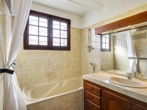 a bathroom with a tub and a sink and a tub and a mirror at Maison Biscarrosse Plage, 4 pièces, 8 personnes - FR-1-521-94 in Biscarrosse-Plage