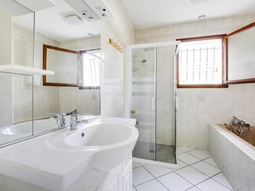 a white bathroom with a sink and a shower at Maison plain-pied à Biscarrosse avec jardin clos, terrasse et parking pour 6 personnes - FR-1-521-105 in Biscarrosse