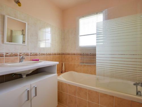 La salle de bains est pourvue d'un lavabo, d'une baignoire et d'une fenêtre. dans l'établissement Maison Moderne à Biscarrosse Bourg, 4 Pers., Près du Centre-Ville, Grand Terrain - FR-1-521-131, à Biscarrosse