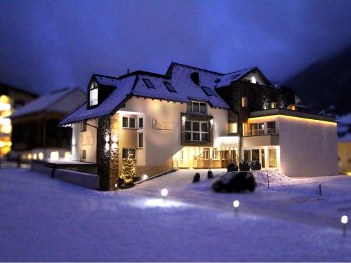 a large house in the snow at night at Relax Apartments in Ischgl