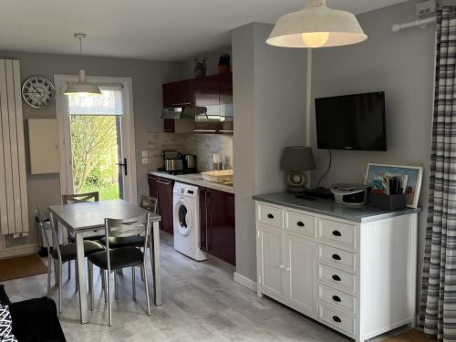 une cuisine avec une table et une salle à manger dans l'établissement Charmant cottage familial près de la thalasso, jardin privatif, parking, Wi-Fi, 6 pers. - FR-1-487-276, à Cabourg