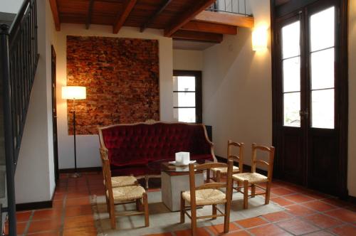 ブエノスアイレスにあるPosada Gotanのリビングルーム(赤いソファ、テーブル、椅子付)