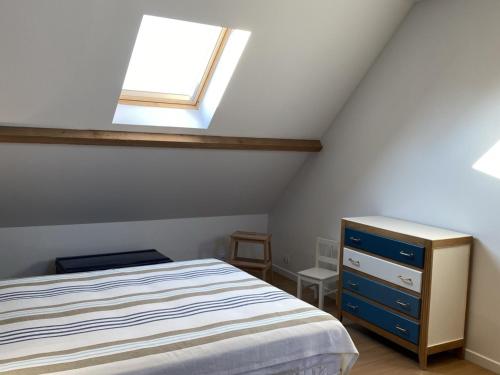 - une chambre mansardée avec un lit et une lucarne dans l'établissement Charmant Cottage avec Jardin à Deux Pas du Port - Dives-sur-Mer - FR-1-487-279, à Dives-sur-Mer