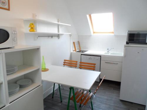 une petite cuisine avec une table et des chaises. dans l'établissement Appartement 3 pièces face à la mer, centre-ville, 54m² pour 5 pers., proche plage, court séjour dispo - FR-1-487-298, à Villers-sur-Mer
