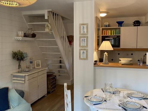 une cuisine et une salle à manger avec une table et un escalier dans l'établissement Charmant Cottage avec Jardin à Deux Pas du Port - Dives-sur-Mer - FR-1-487-279, à Dives-sur-Mer