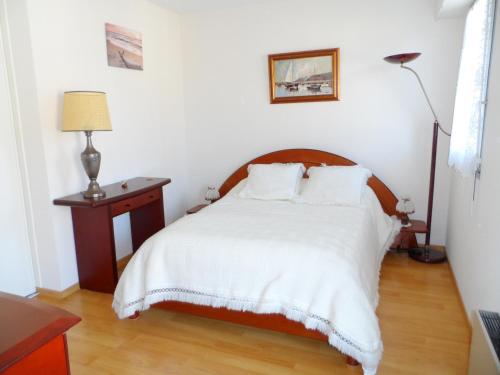 a bedroom with a bed with white sheets and a lamp at Cabourg: Appartement 2 pièces proche plage avec piscine et parking - FR-1-487-299 in Cabourg