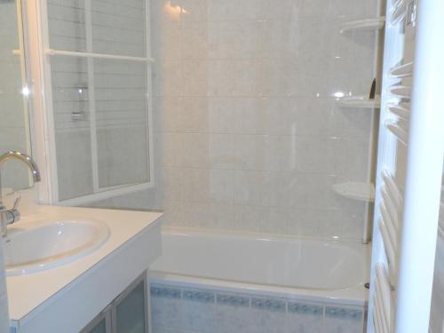 een witte badkamer met een wastafel en een douche bij Appartement Cabourg, 2 pièces, 4 personnes - FR-1-487-170 in Cabourg