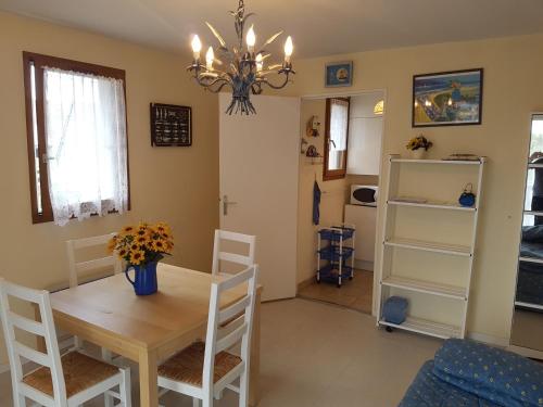 une salle à manger avec une table, des chaises et un lustre dans l'établissement Appartement 2 pièces à Cabourg - Proche plage et centre-ville, balcon et parking privé - FR-1-487-300, à Cabourg