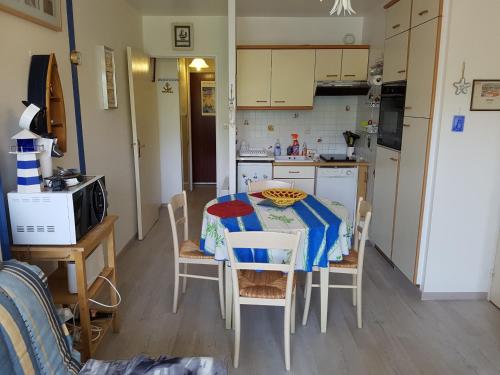 una cocina con mesa y sillas y una cocina con mesa y mesa. en Appartement Cabourg, 2 pièces, 4 personnes - FR-1-487-290, en Cabourg
