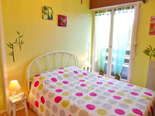 1 dormitorio con 1 cama con manta de lunares en Appartement Cabourg, 2 pièces, 4 personnes - FR-1-487-290, en Cabourg