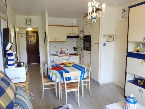 cocina y comedor con mesa y sillas en Appartement Cabourg, 2 pièces, 4 personnes - FR-1-487-290, en Cabourg