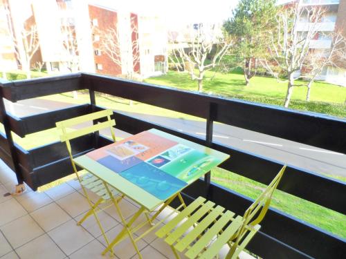 uma varanda com 2 cadeiras, uma mesa e uma janela em Appartement Cabourg, 2 pièces, 4 personnes - FR-1-487-290 em Cabourg