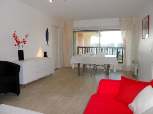 un salon avec un canapé rouge et une table dans l'établissement CABOURG - 2P Proche Plage avec Balcon et Parking - FR-1-487-292, à Cabourg