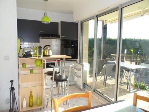 une cuisine avec un comptoir et une table avec des chaises dans l'établissement Appartement T2 avec Jardin, Proche Centre et Plage de Cabourg, Parking Inclus - FR-1-487-295, à Cabourg