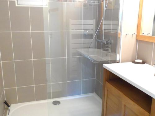 La salle de bains est pourvue d'une douche et d'un lavabo blanc. dans l'établissement Appartement T2 avec Jardin, Proche Centre et Plage de Cabourg, Parking Inclus - FR-1-487-295, à Cabourg