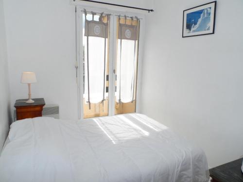 un lit blanc dans une chambre avec une fenêtre dans l'établissement Appartement 2 pièces avec balcon ensoleillé près de l'hippodrome de Cabourg - FR-1-487-297, à Cabourg