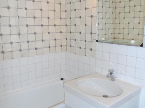 une salle de bain blanche avec un lavabo et un miroir dans l'établissement Appartement 2 pièces avec balcon ensoleillé près de l'hippodrome de Cabourg - FR-1-487-297, à Cabourg
