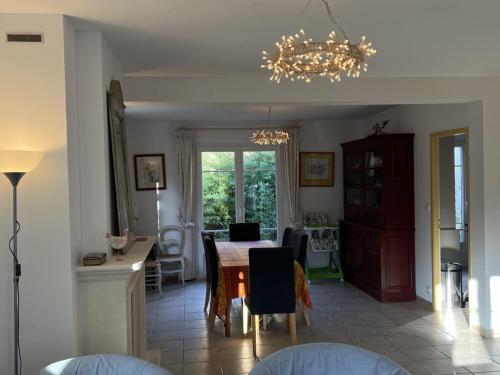 une salle à manger avec une table et un lustre dans l'établissement Grande Villa avec Jardin, Proche Plage et Centre de Villers-sur-Mer - FR-1-487-310, à Villers-sur-Mer