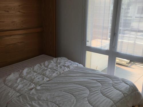 - un lit non aménagé dans une chambre avec fenêtre dans l'établissement Appartement 2 pièces avec terrasse près de la plage - Merville-Franceville - FR-1-487-311, à Merville-Franceville-Plage