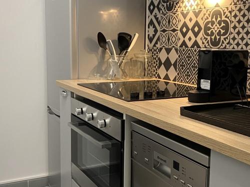 une cuisine avec un évier et une cuisinière four supérieur dans l'établissement Charmant 2 pièces avec parking et ascenseur, proche centre-ville de Cabourg - FR-1-487-323, à Cabourg