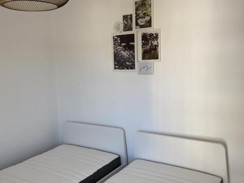 - 2 lits dans une chambre avec des photos sur le mur dans l'établissement Charmant 2 pièces avec parking et ascenseur, proche centre-ville de Cabourg - FR-1-487-323, à Cabourg