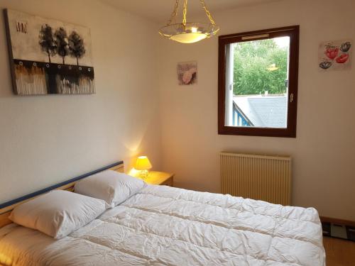 une chambre avec un lit blanc et une fenêtre dans l'établissement Charmant T2 à Cabourg, proche plage et centre-ville, balcon et parking gratuit - FR-1-487-312, à Cabourg