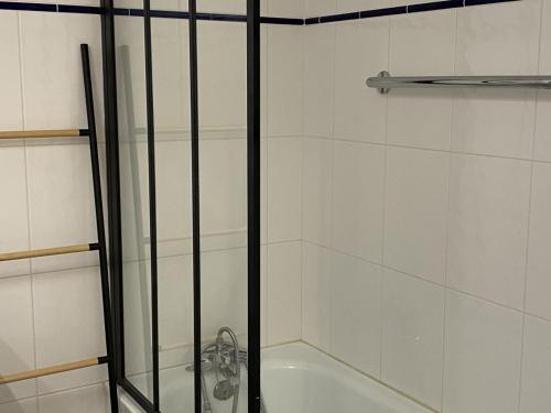 d'une douche avec une porte en verre à côté d'une baignoire. dans l'établissement Charmant 2 pièces avec parking et ascenseur, proche centre-ville de Cabourg - FR-1-487-323, à Cabourg
