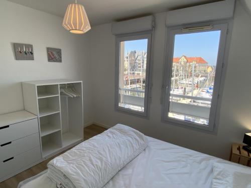 una camera con un letto e due finestre di Appartement Dives-sur-Mer, 4 pièces, 6 personnes - FR-1-487-314 a Dives-sur-Mer